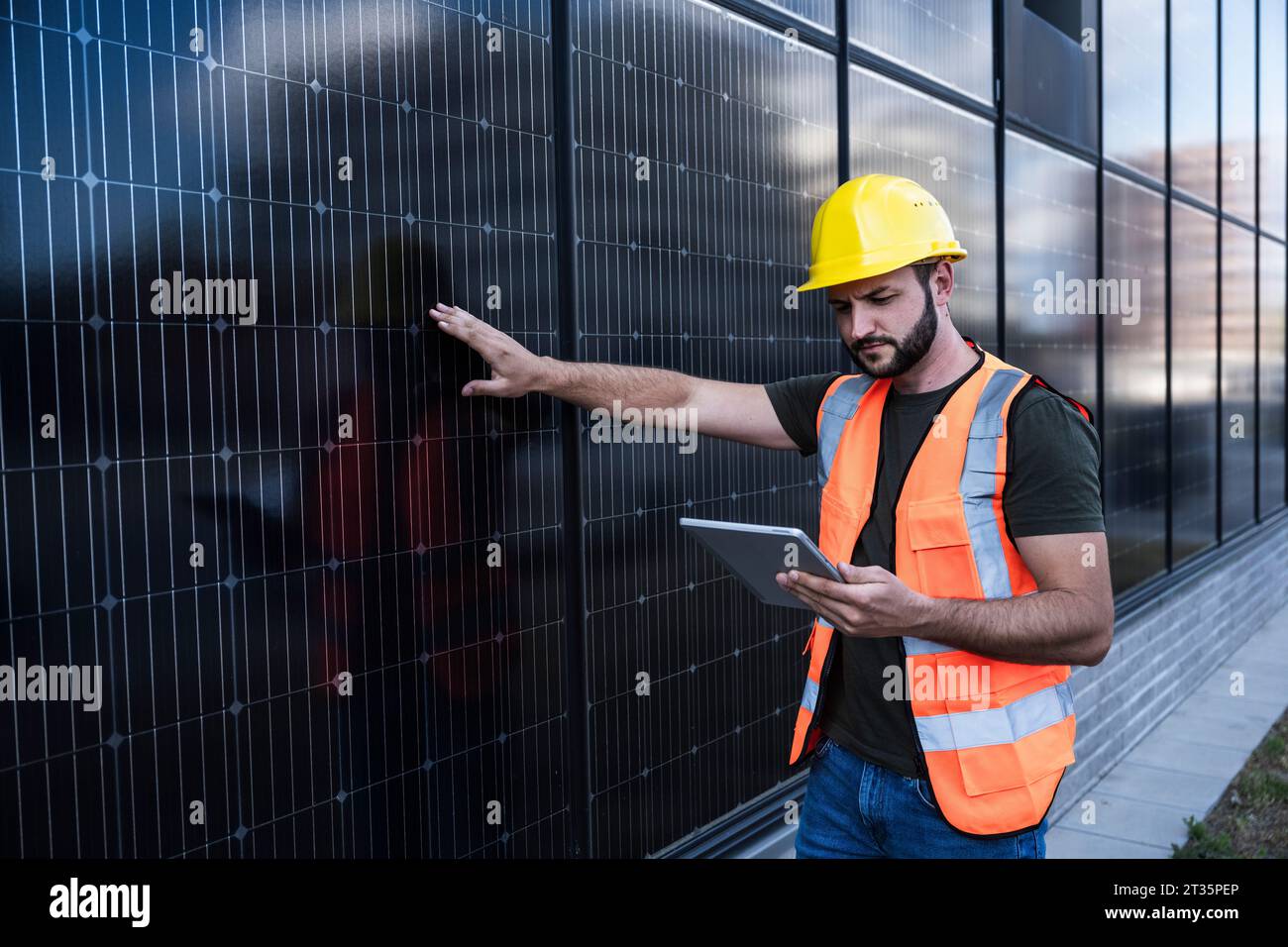 Engineer examining solar panels using tablet PC Stock Photo