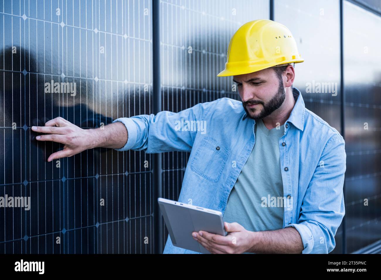 Engineer examining solar panels using tablet PC Stock Photo