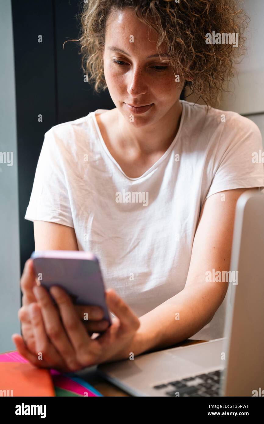Businesswoman using smart phone at cafe Stock Photo