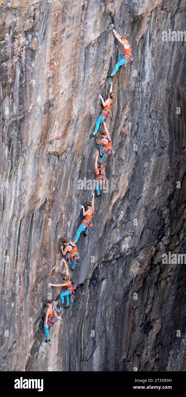 Woman climbing rocky mountain with rope Stock Photo