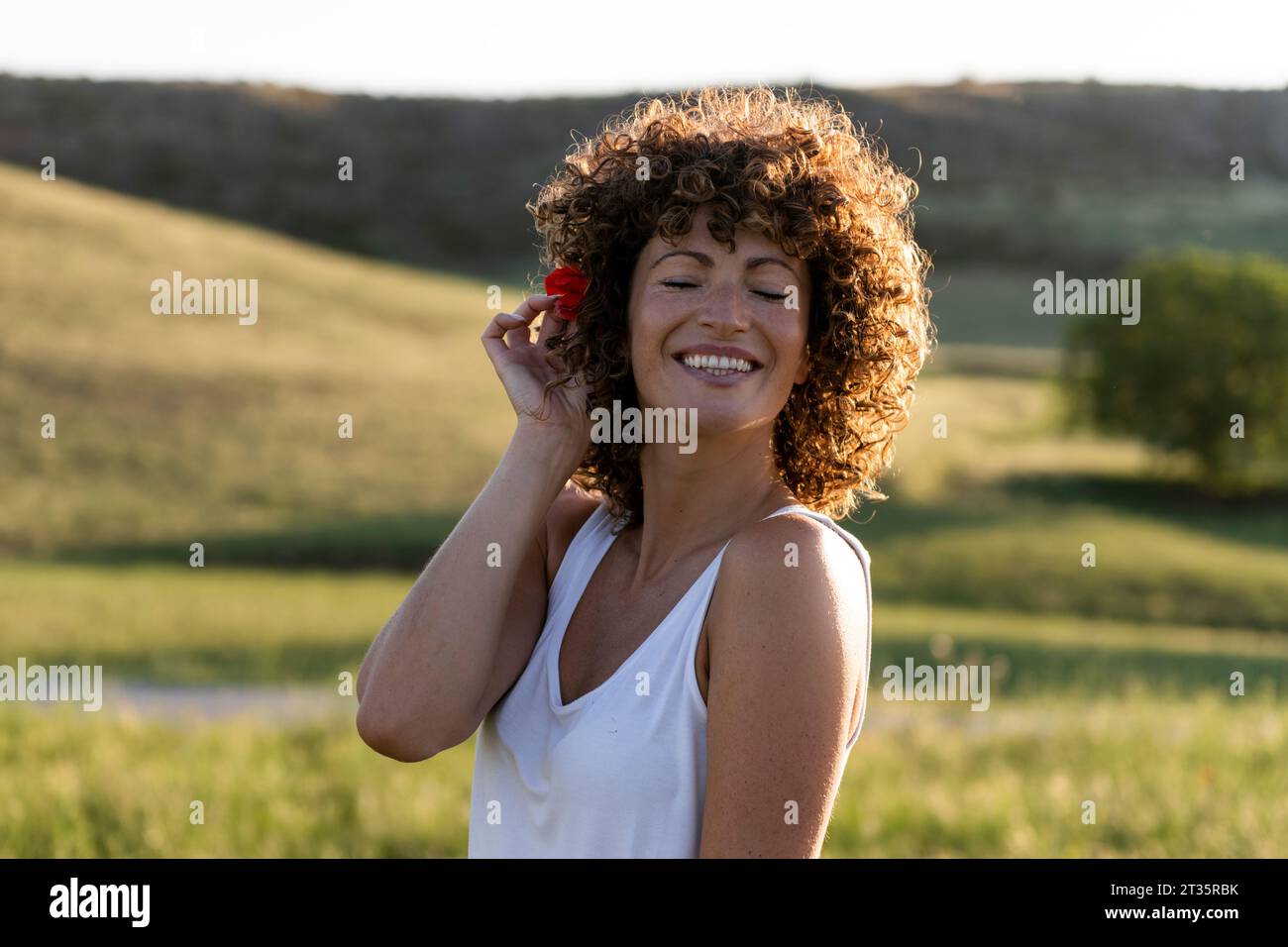 Happy woman with flower on sunny day Stock Photo
