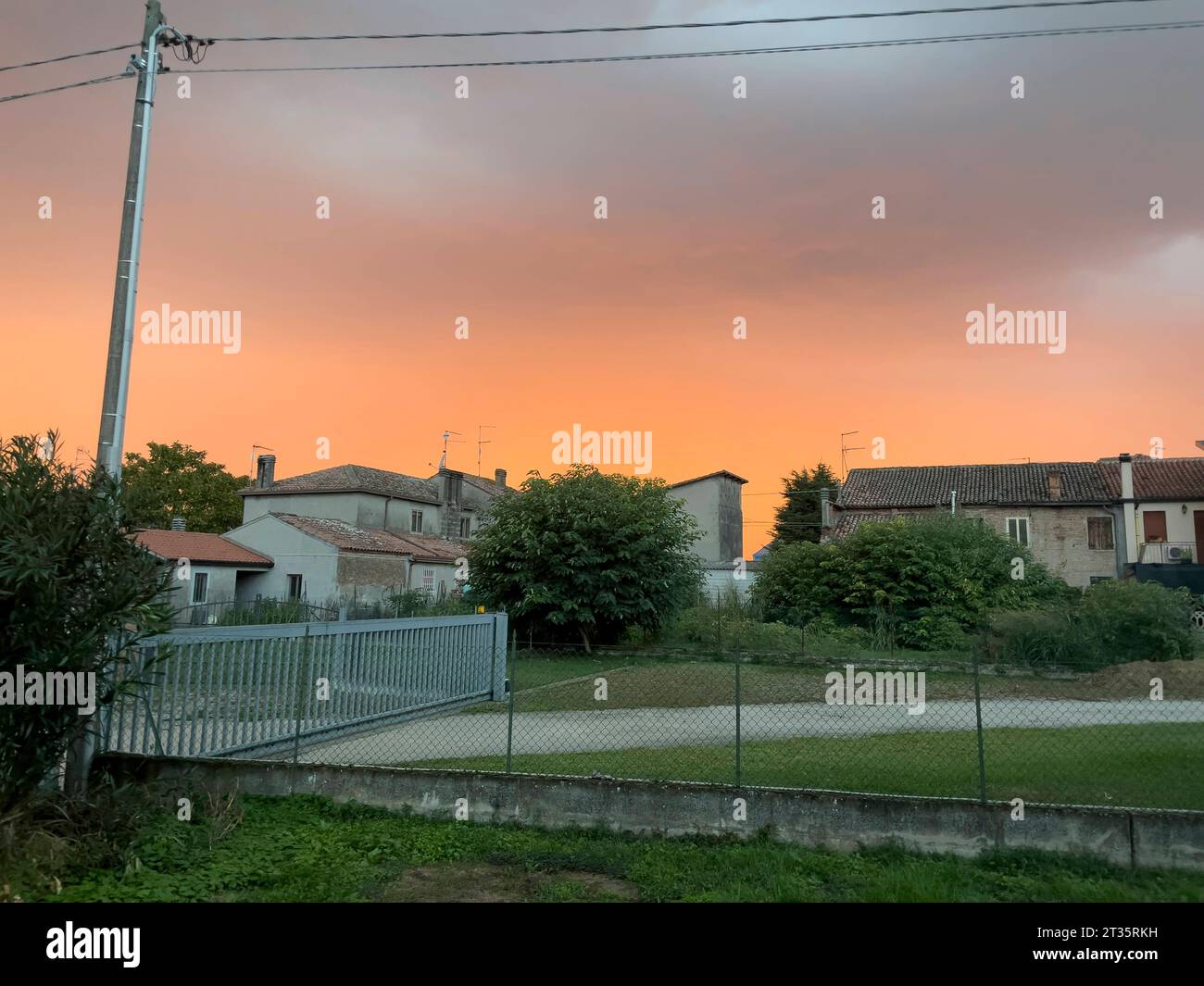 Golden hues of sunset filter through the silhouette of urban houses, casting a serene ambiance. Sunset Amidst City Homes Copyright: xx IMG 004899 Credit: Imago/Alamy Live News Stock Photo