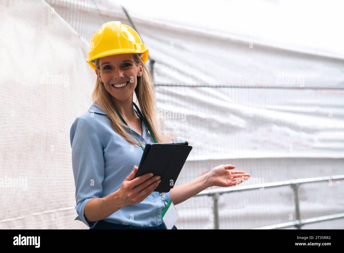 Smiling engineer gesturing holding tablet PC Stock Photo
