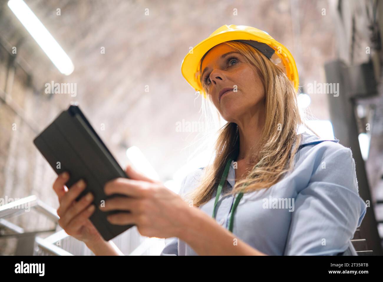 Thoughtful engineer holding tablet PC Stock Photo