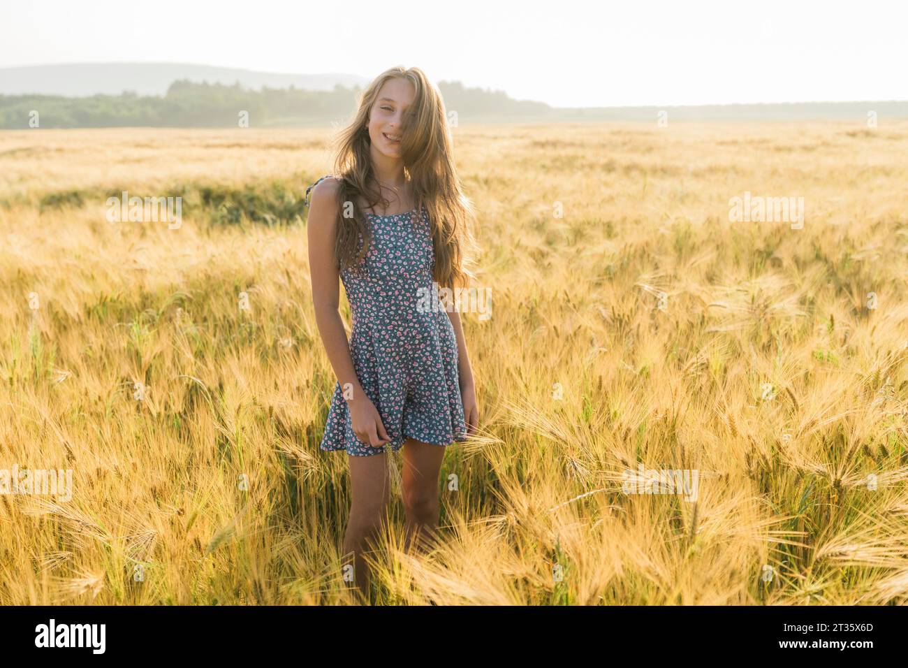 Smiling girl standing amidst wheat crop in field Stock Photo - Alamy