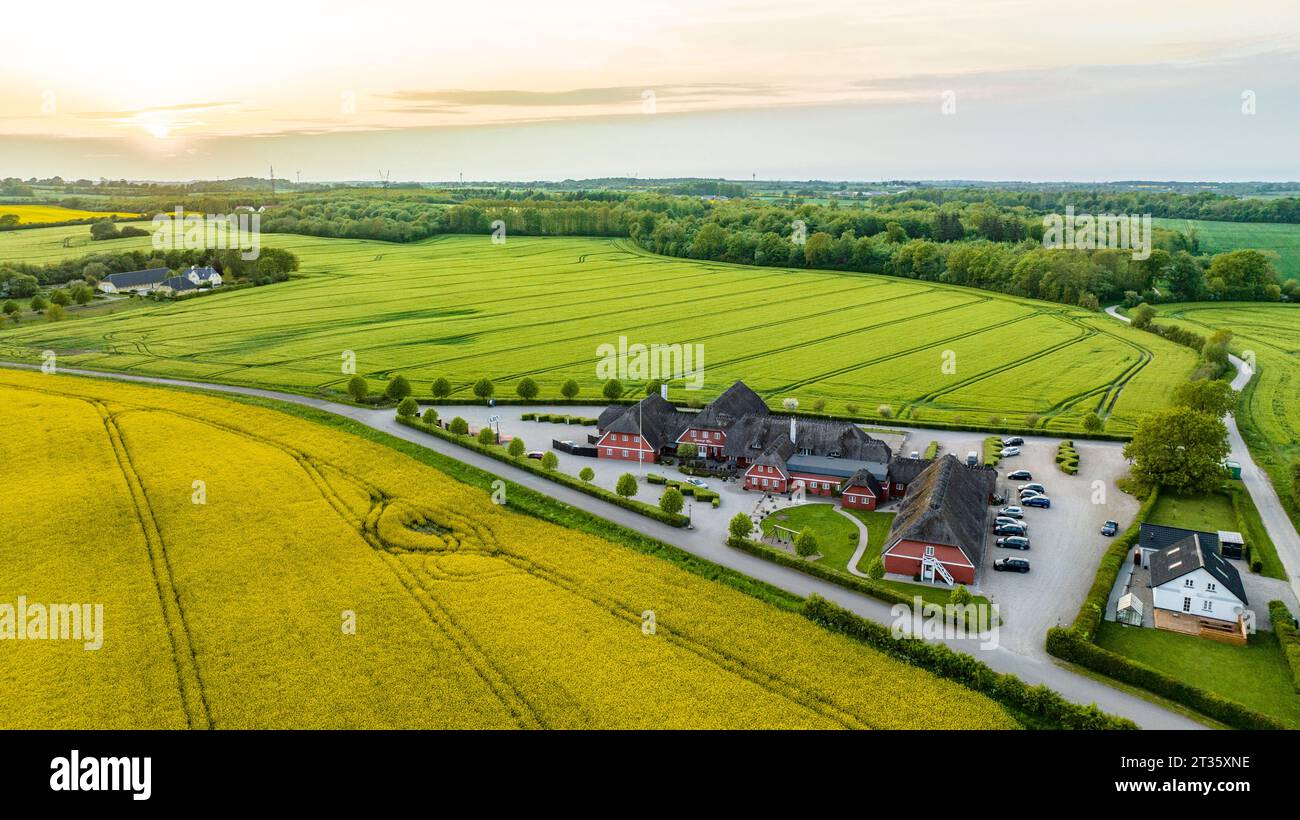 Denmark, Syddanmark, Christiansfeld, Aerial view of village surrounded by summer fields at sunset Stock Photo