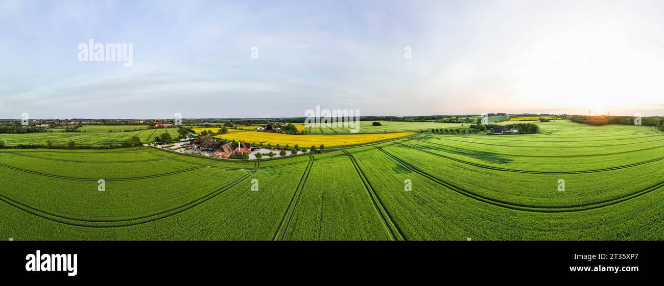 Denmark, Syddanmark, Christiansfeld, Aerial panorama of village surrounded by summer fields at sunset Stock Photo