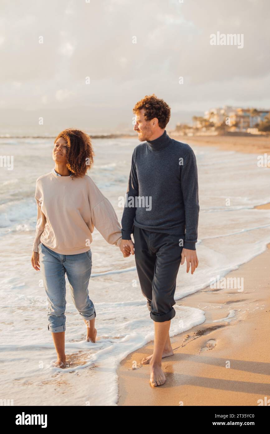 Happy multicultural couple holding hands hi-res stock photography and ...
