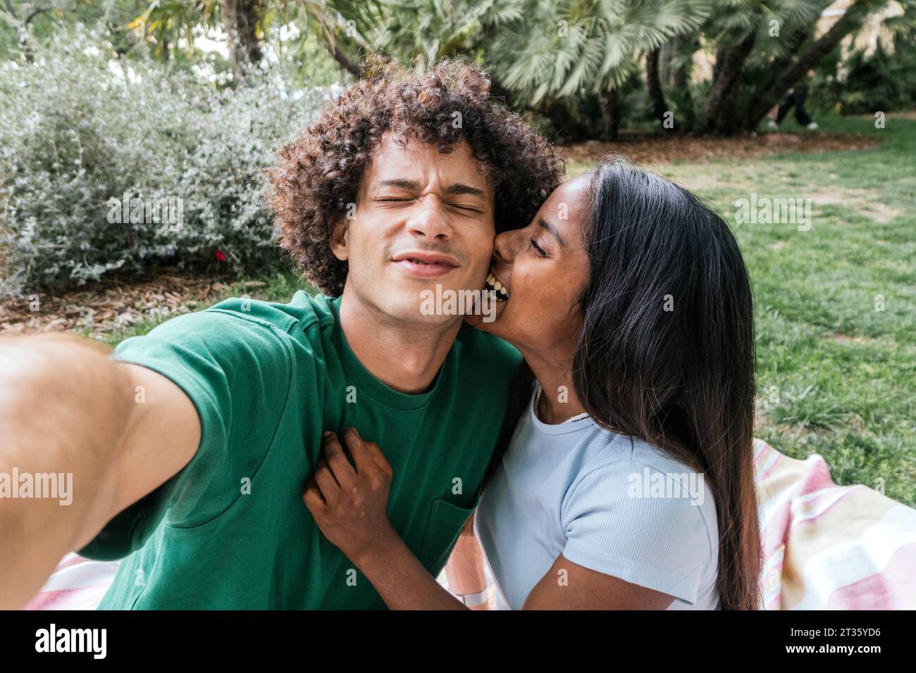 Smiling girlfriend hugging boyfriend in park Stock Photo - Alamy