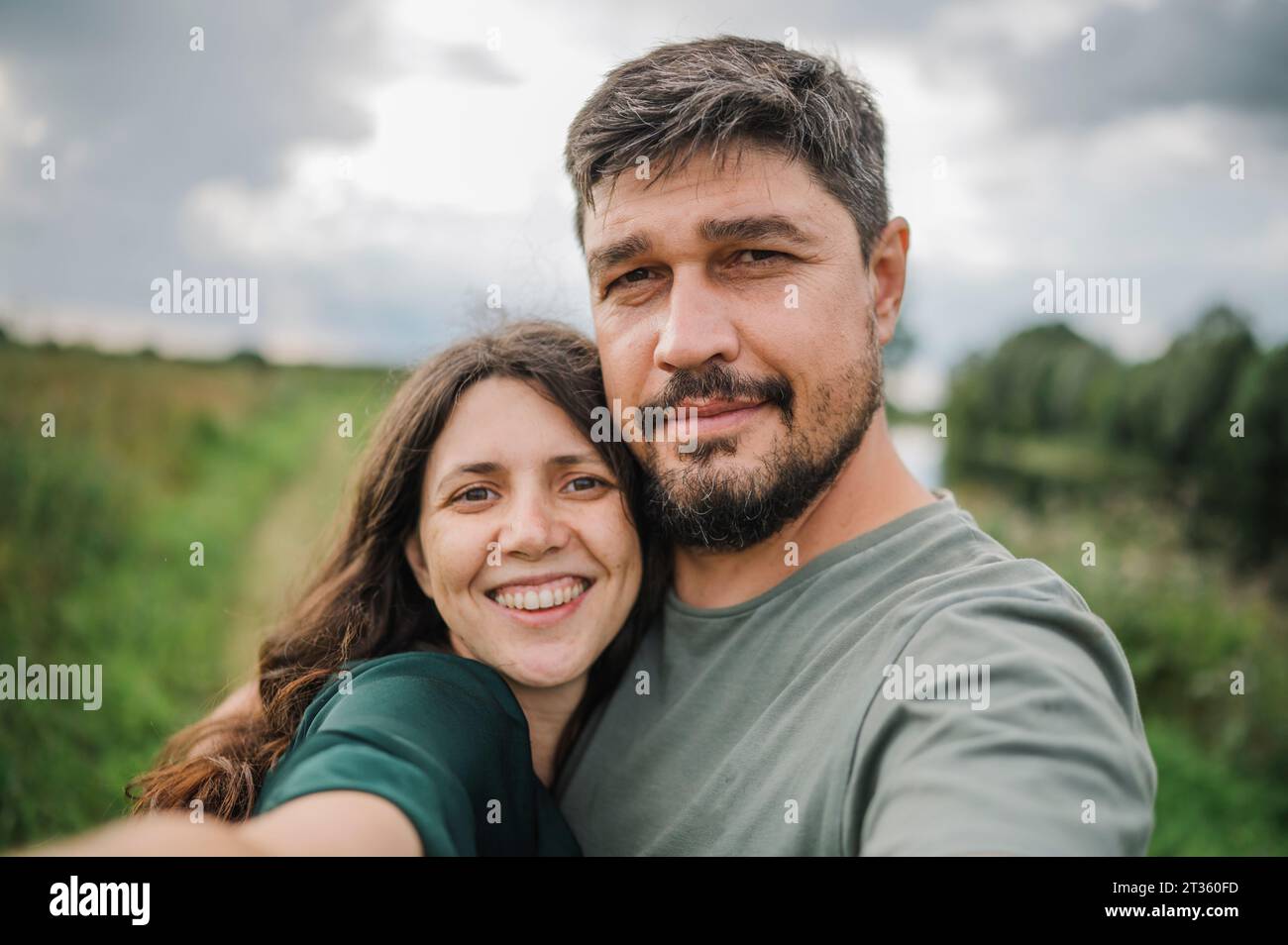 Smiling woman taking selfie with man Stock Photo
