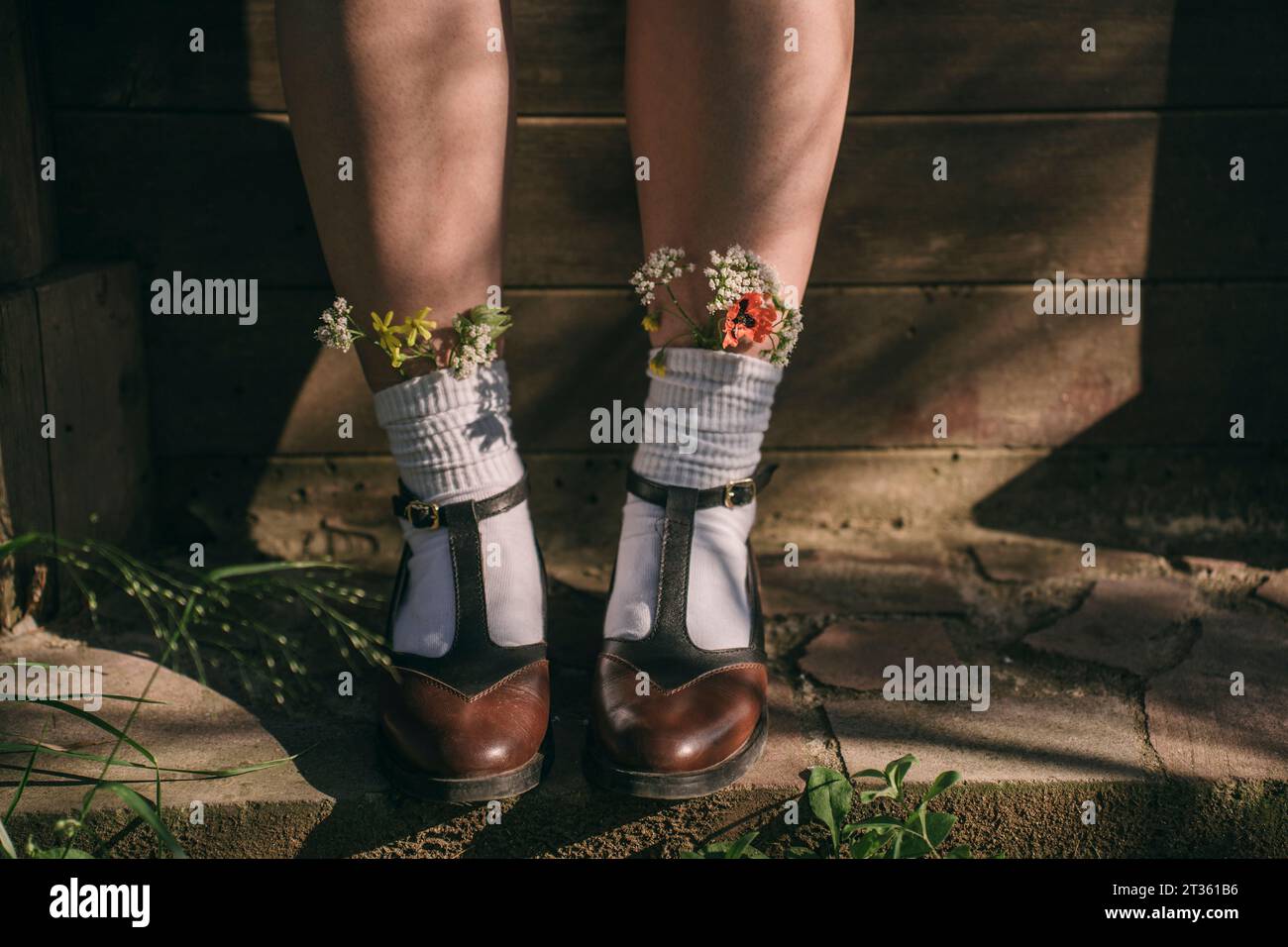 Woman wearing vintage shoes with wildflowers in white socks Stock Photo