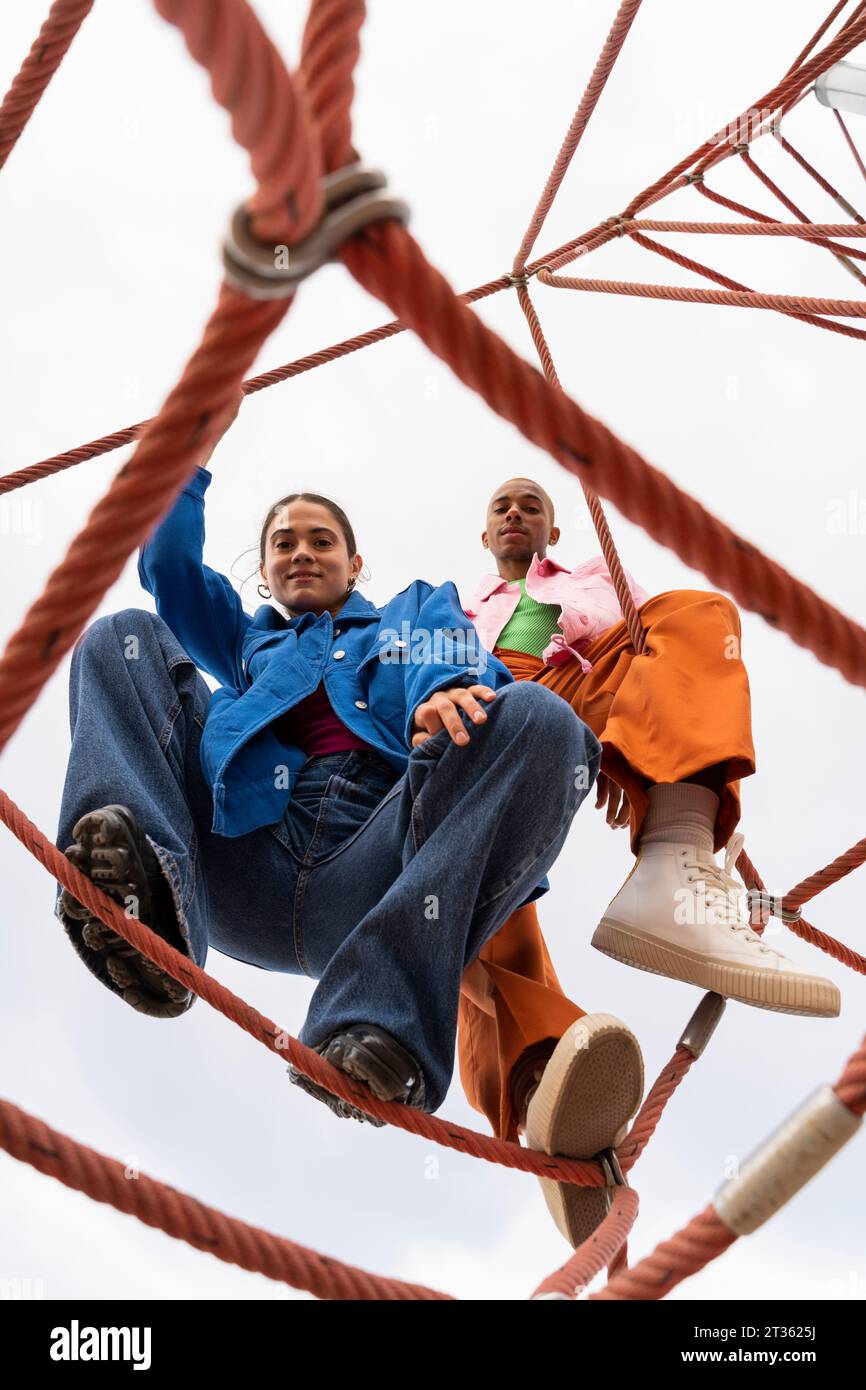 Smiling couple spending leisure time on rope equipment in park Stock Photo