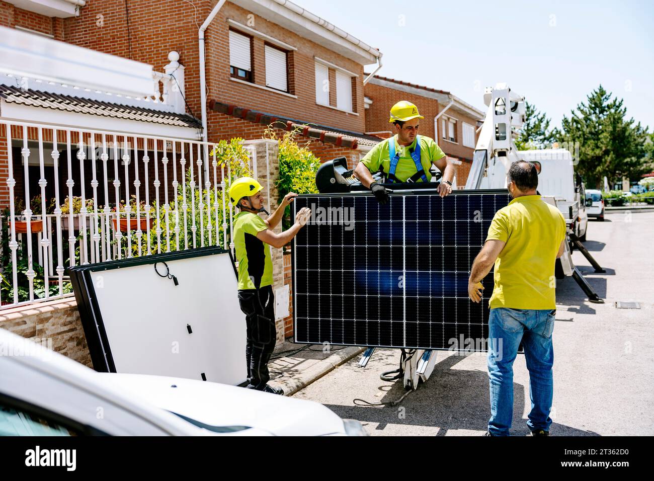 Engineers holding solar panel and standing on road Stock Photo