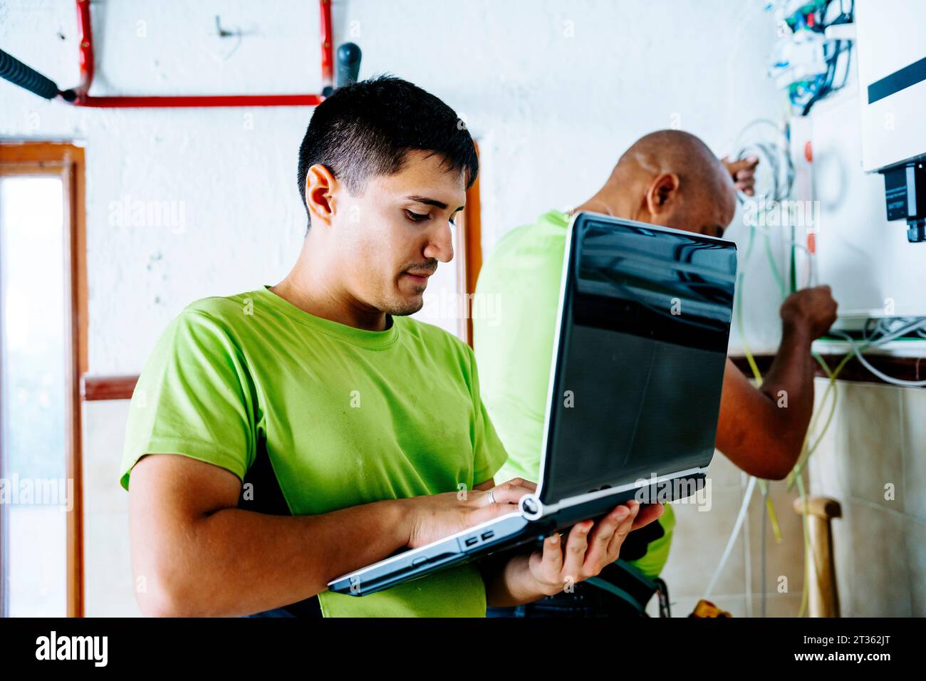 Engineer using laptop with colleague working in background Stock Photo