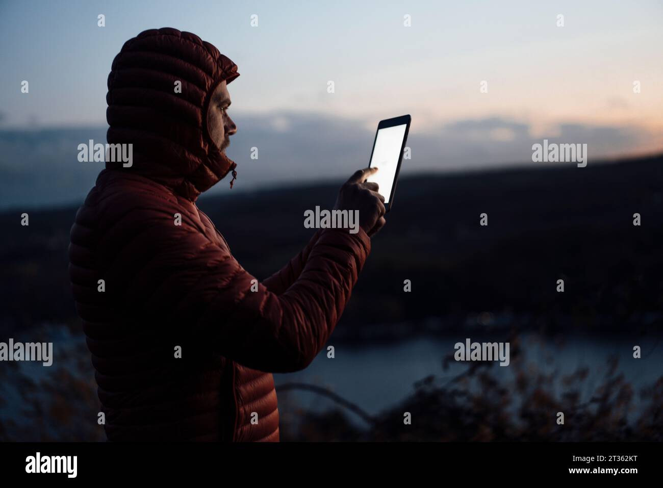 Mature man using tablet PC at dusk Stock Photo