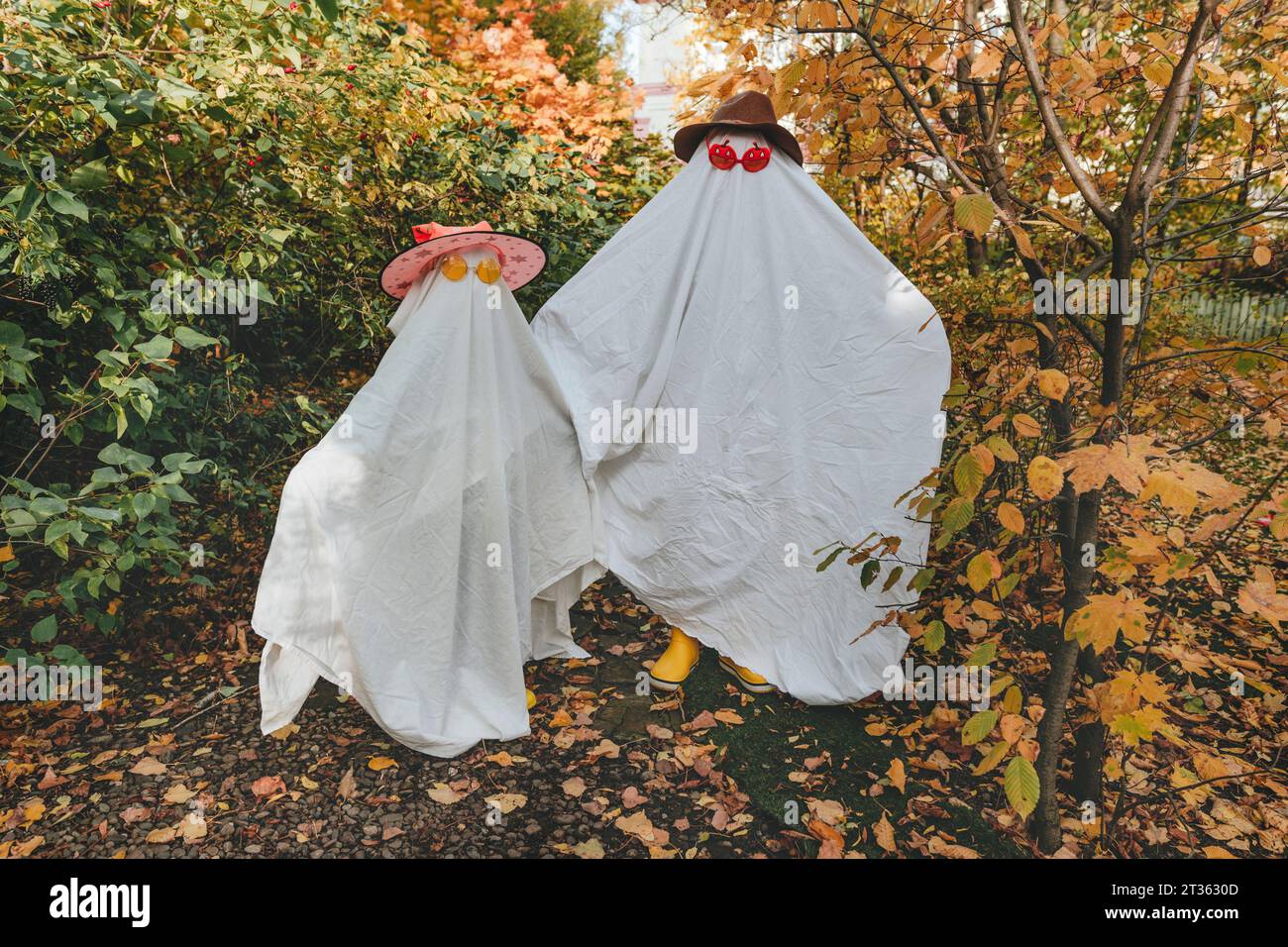 Playful girls in white color costumes standing in garden Stock Photo