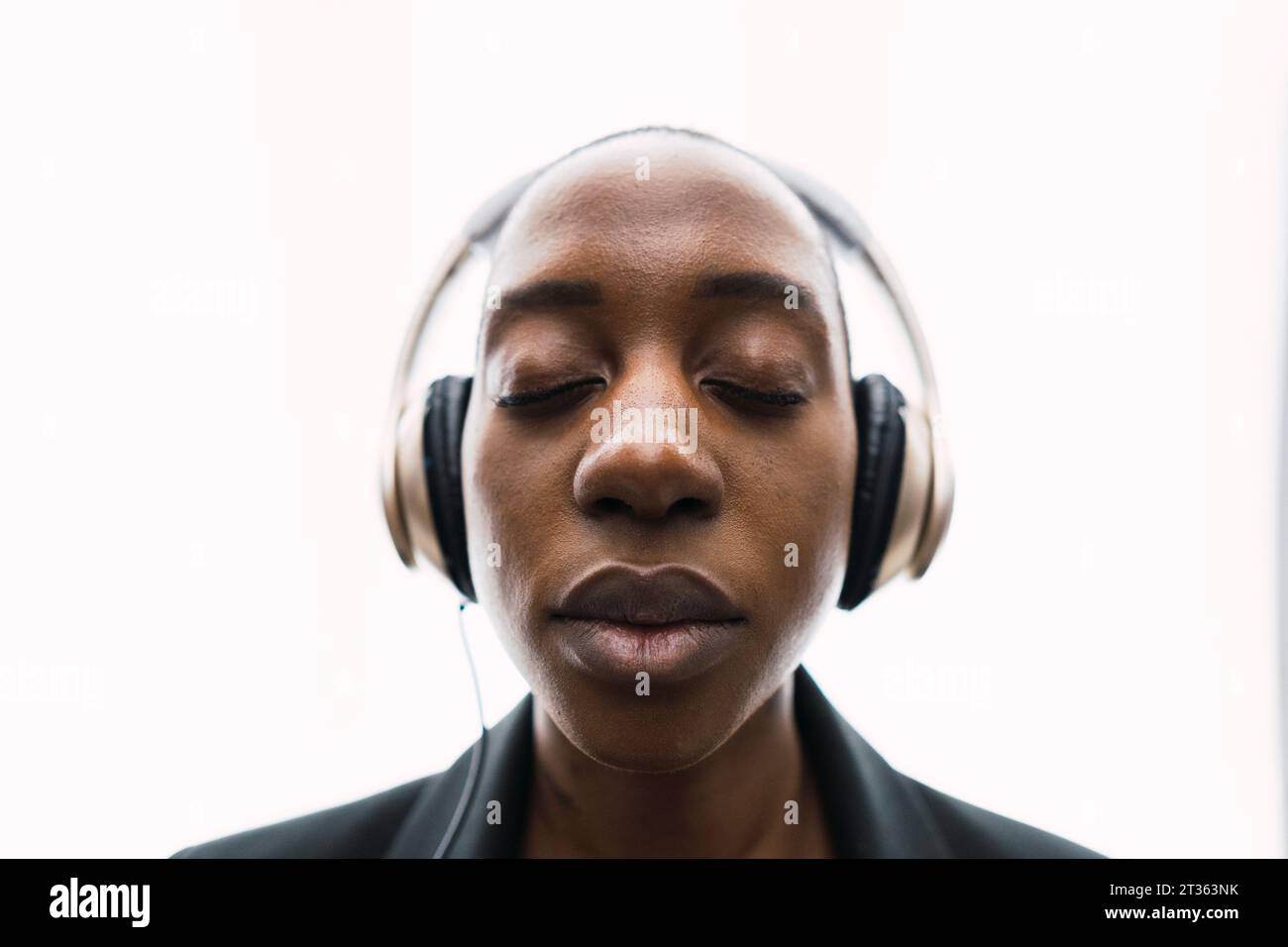 Young woman wearing headphones against white background Stock Photo - Alamy