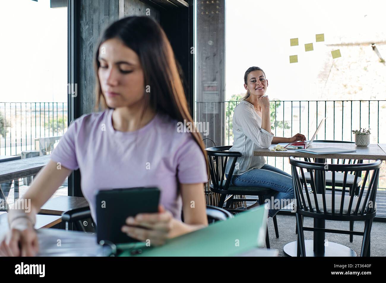 Two young women working at coworking space Stock Photo