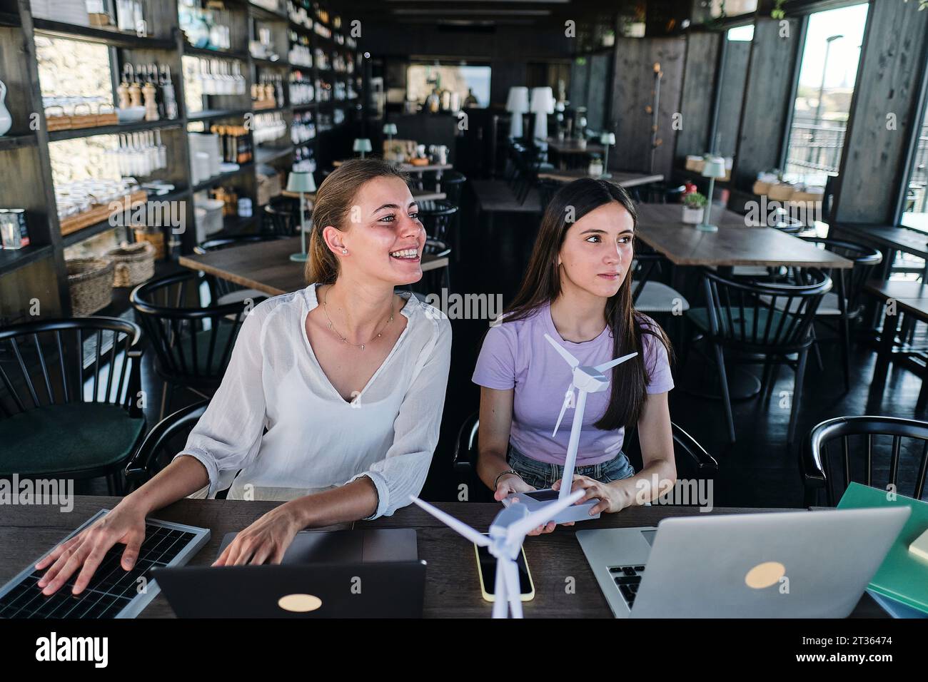 Young women testing solar panel while working at coworking space Stock Photo