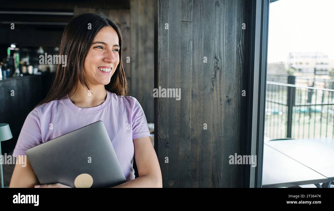 Portrait of beautiful brunette woman holding laptop Stock Photo