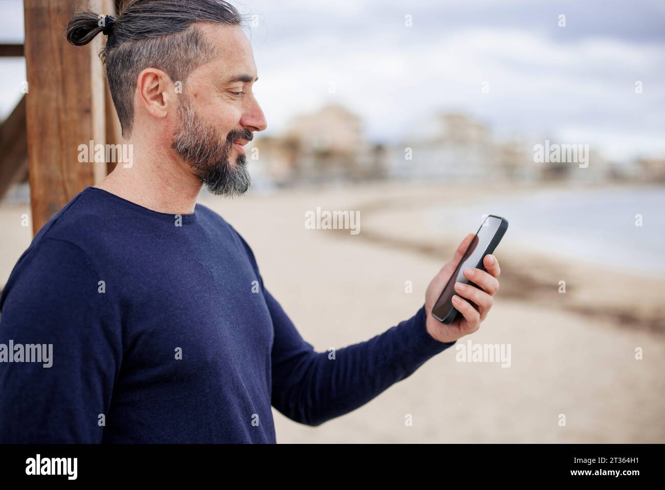 Mature man using smart phone at beach Stock Photo