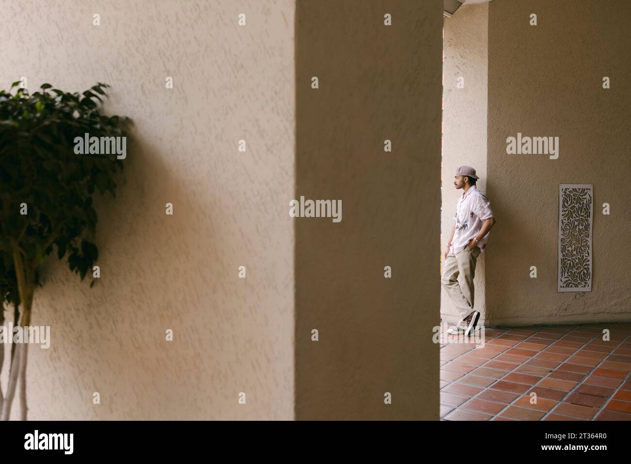 Thoughtful young man leaning on wall Stock Photo