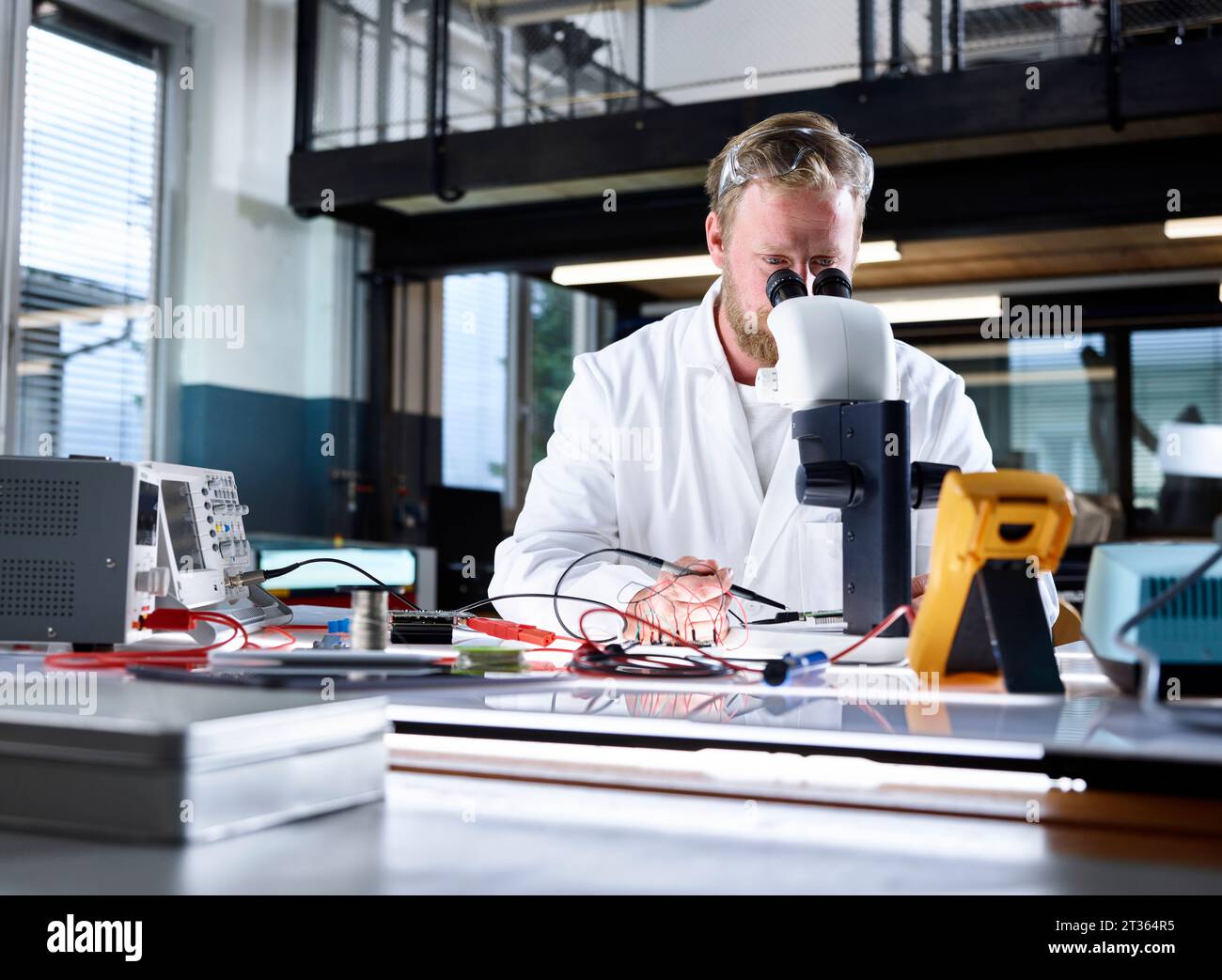 Scientist examining through microscope in laboratory Stock Photo