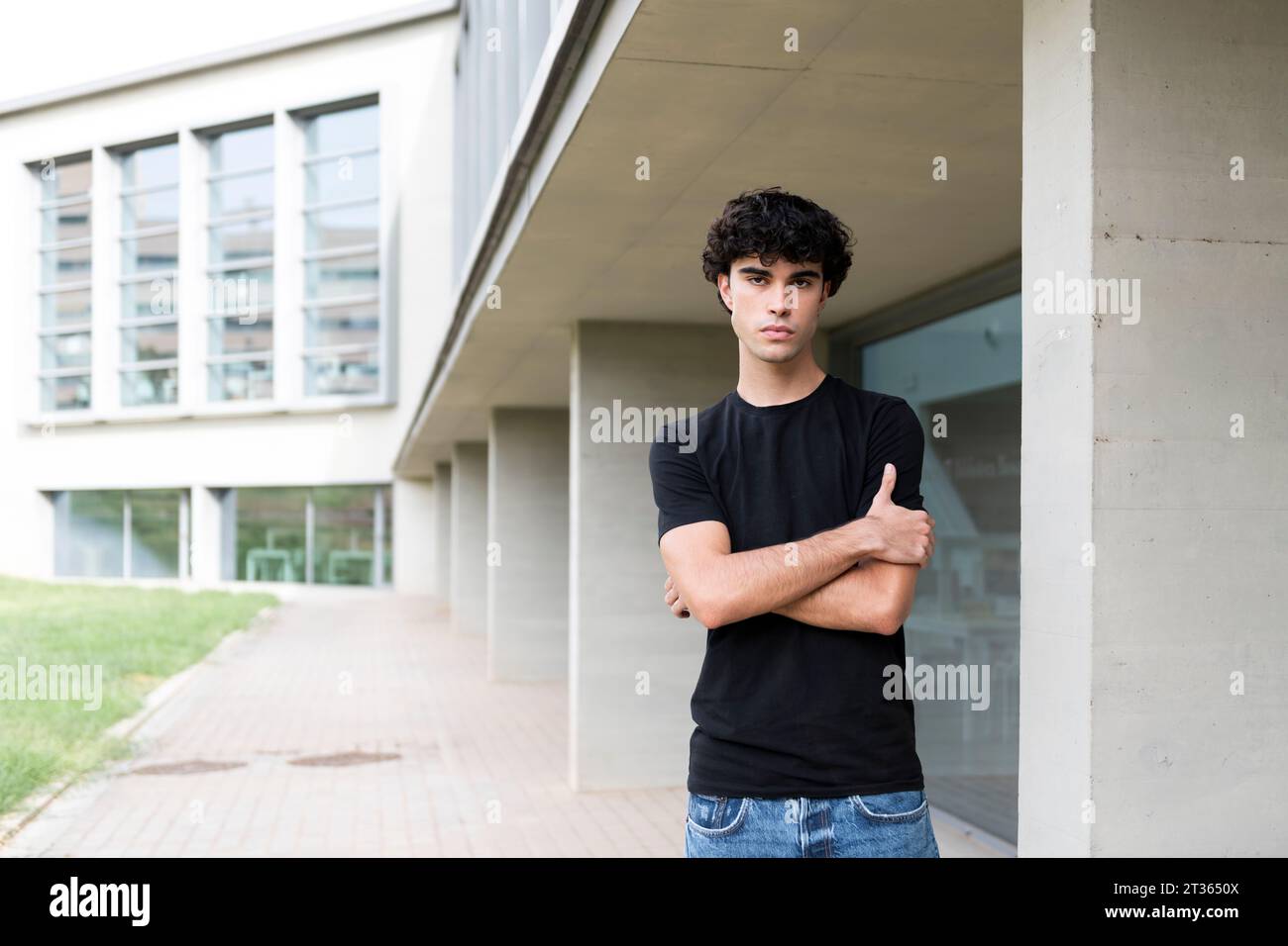 Young man with arms crossed standing near building Stock Photo