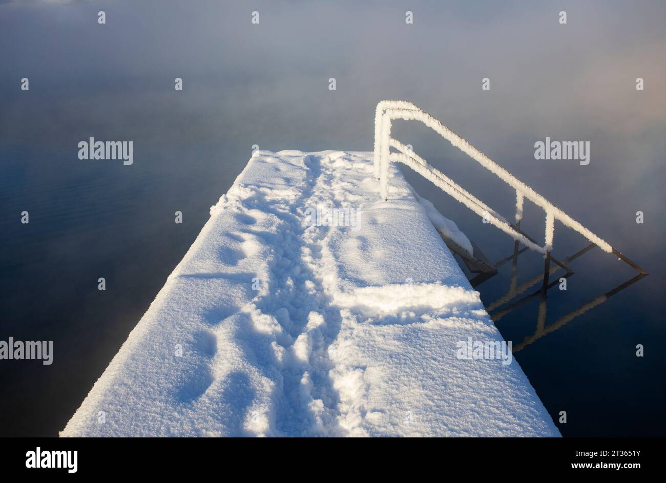 Austria, Upper Austria, Zell am Moos, Snow-covered jetty on shore of Irrsee lake Stock Photo