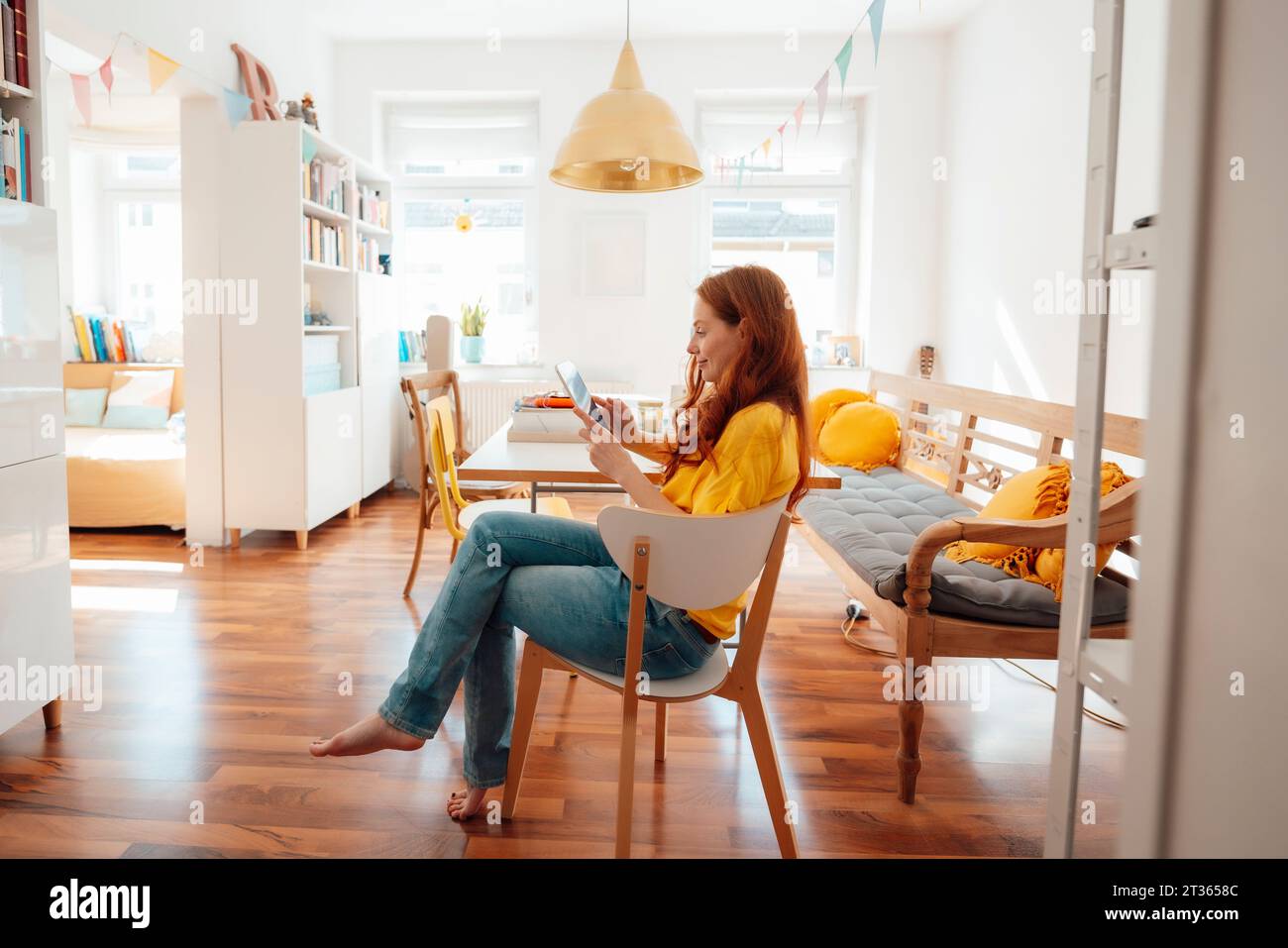 Redhead woman using tablet PC at home Stock Photo
