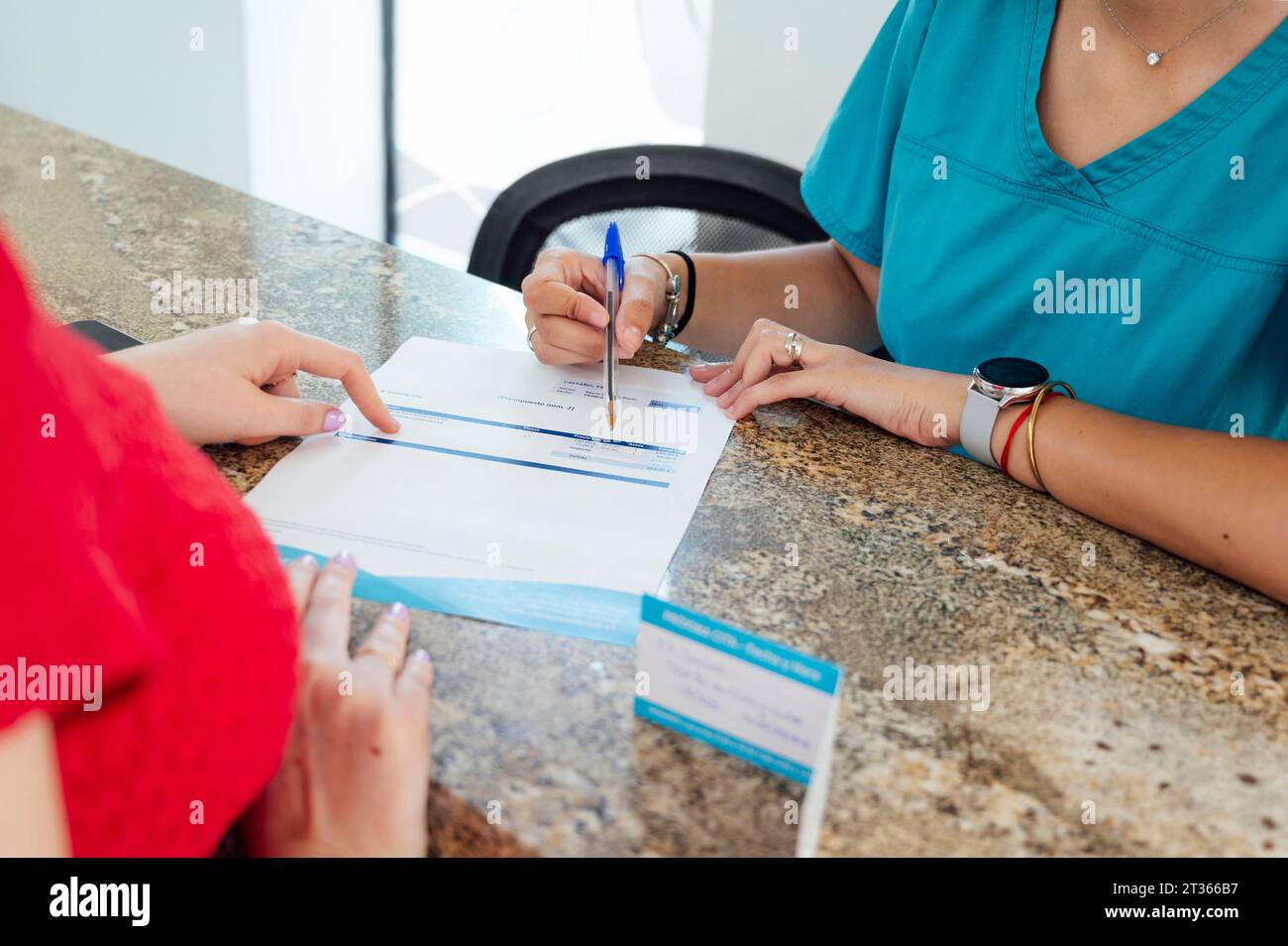 Receptionist giving prescription to patient at checkout in clinic Stock Photo