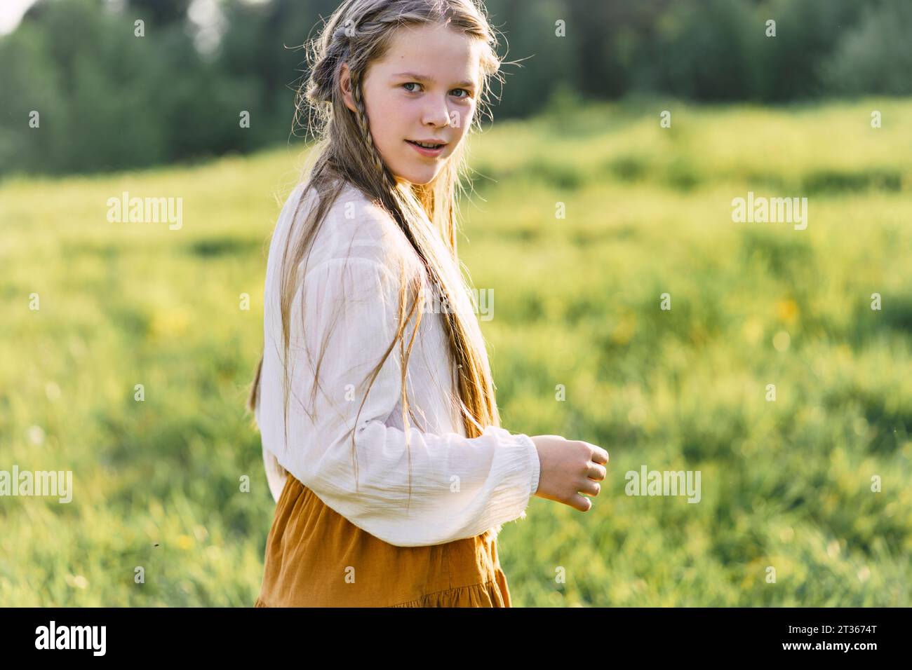Happy girl standing in meadow Stock Photo - Alamy