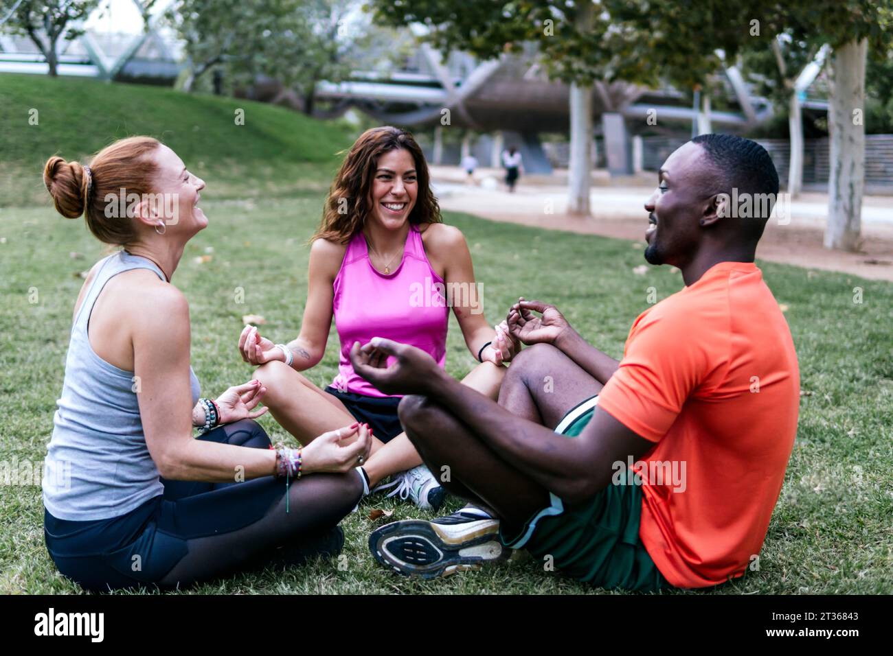 Happy multi-ethnic friends doing yoga in park Stock Photo
