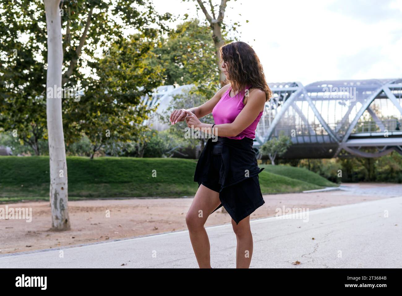 Woman using smart watch standing at park Stock Photo