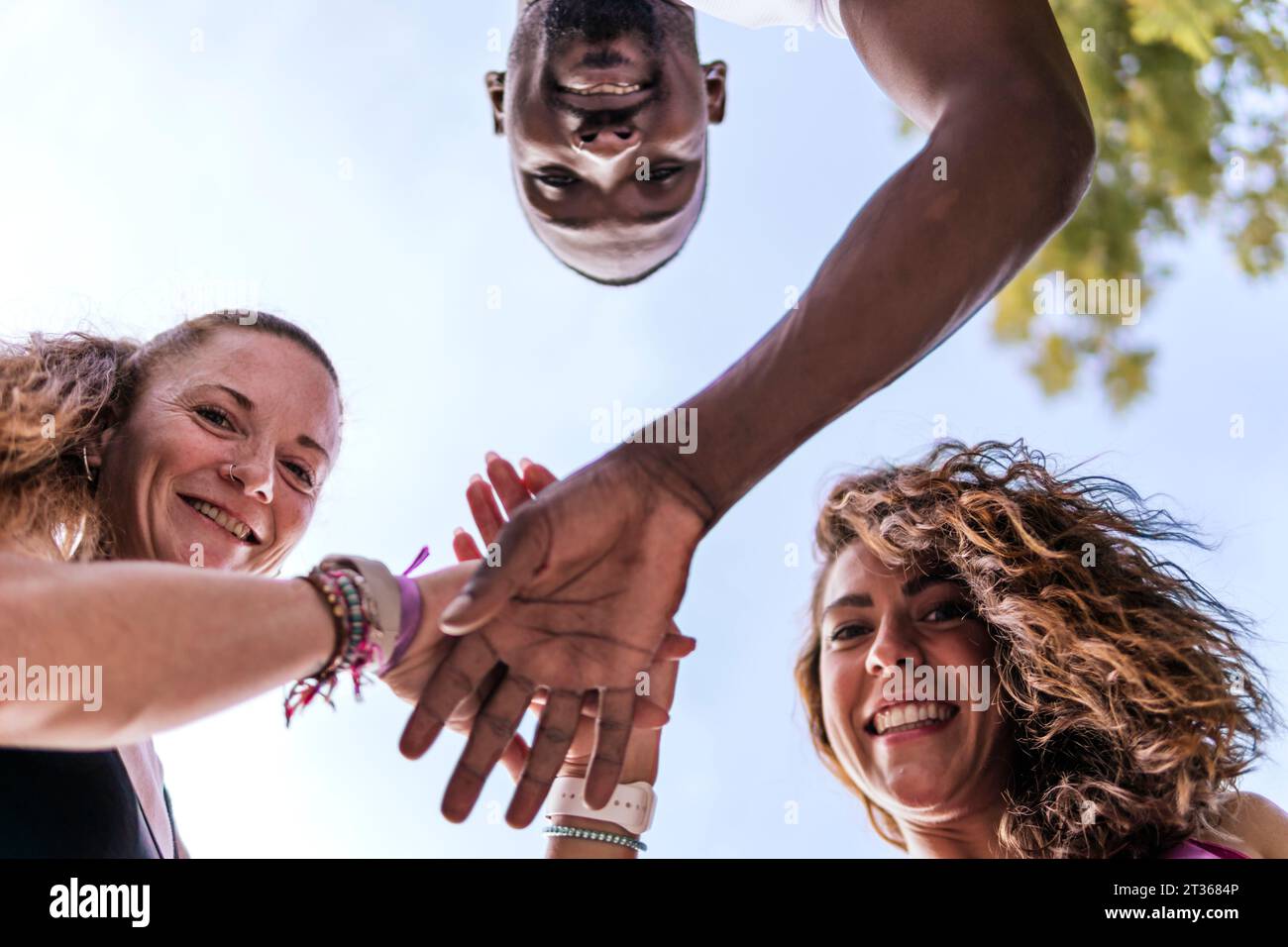 Happy multiracial friends stacking hands Stock Photo