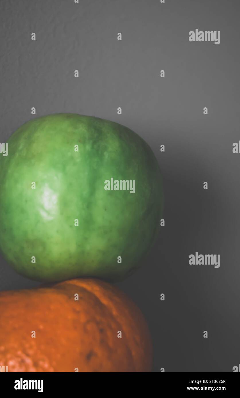 View of orange and apple against grey background Stock Photo - Alamy