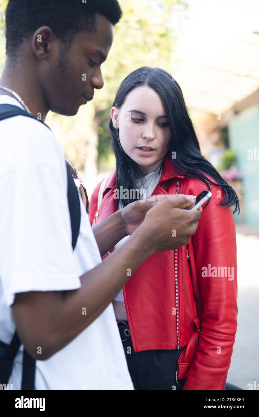 Young woman with man using smart phone Stock Photo