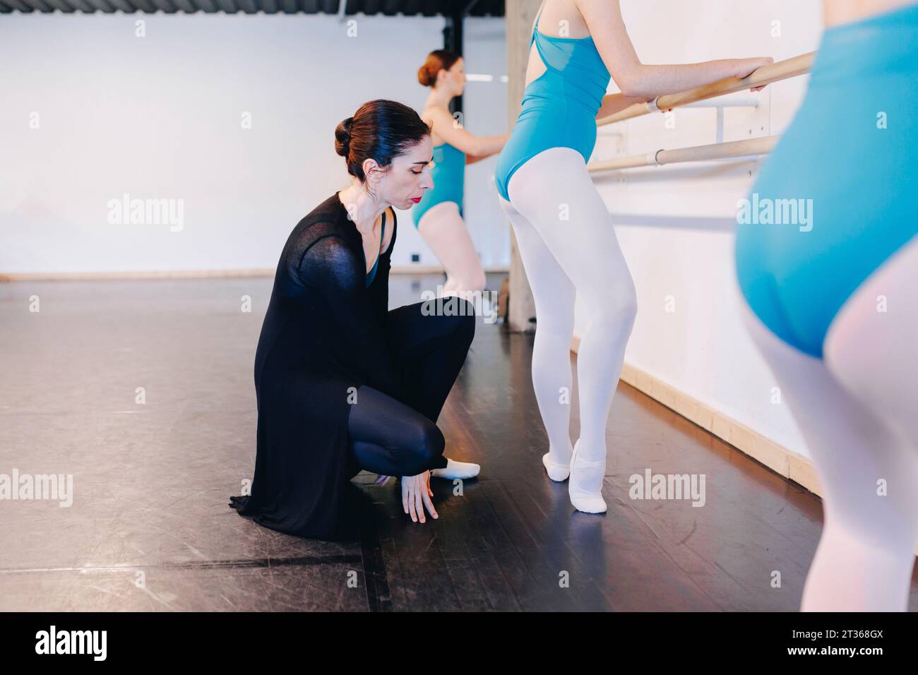 Instructor examining posture of ballet student in dance school Stock Photo