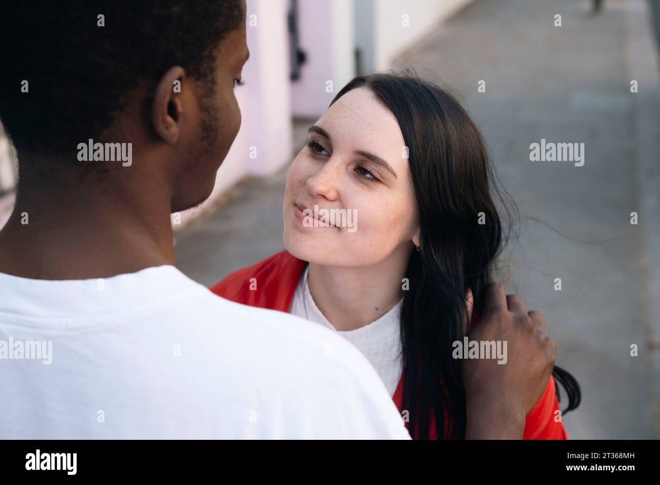 Smiling young woman looking at man Stock Photo