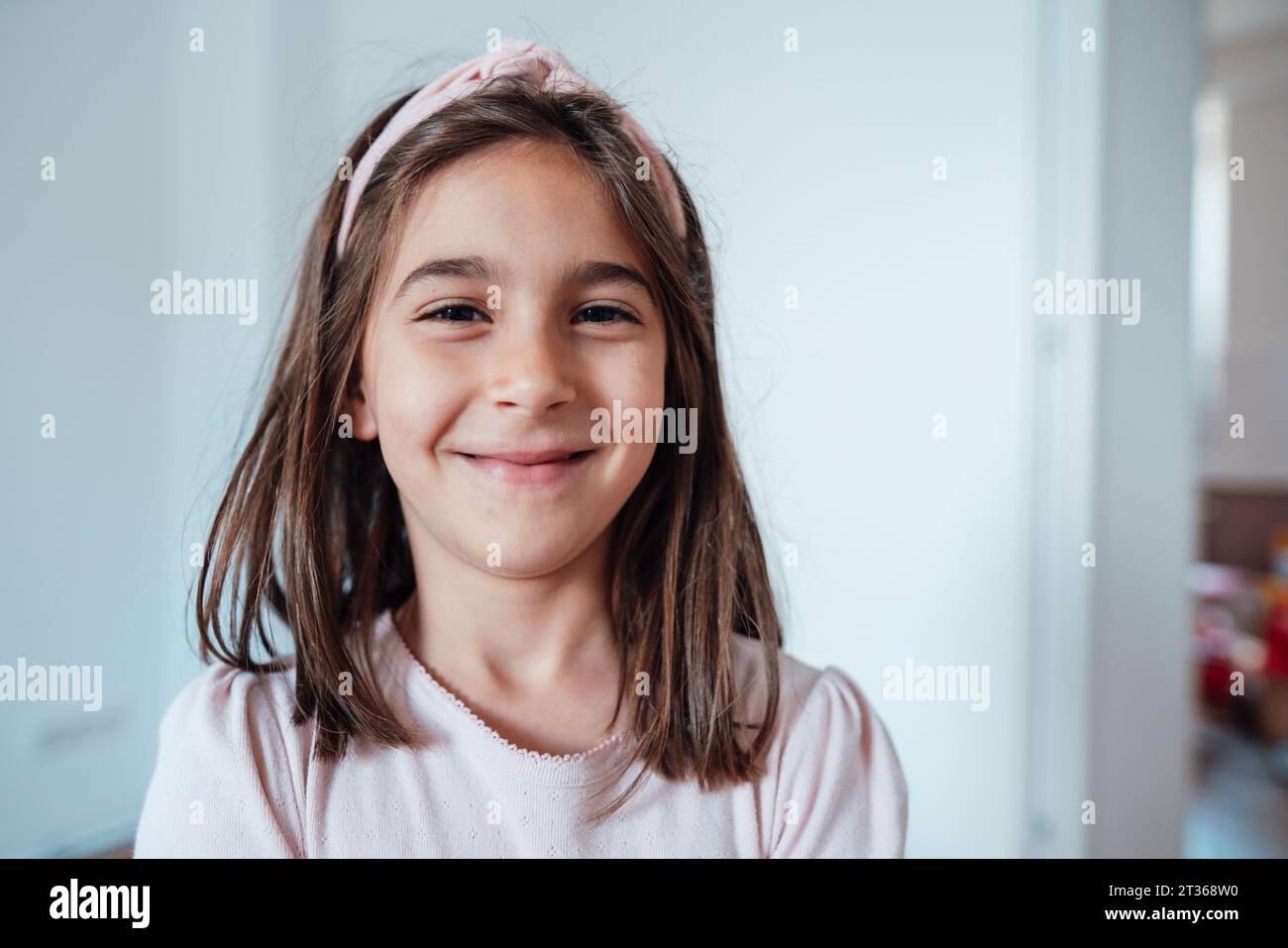 Smiling girl in front of wall at home Stock Photo - Alamy