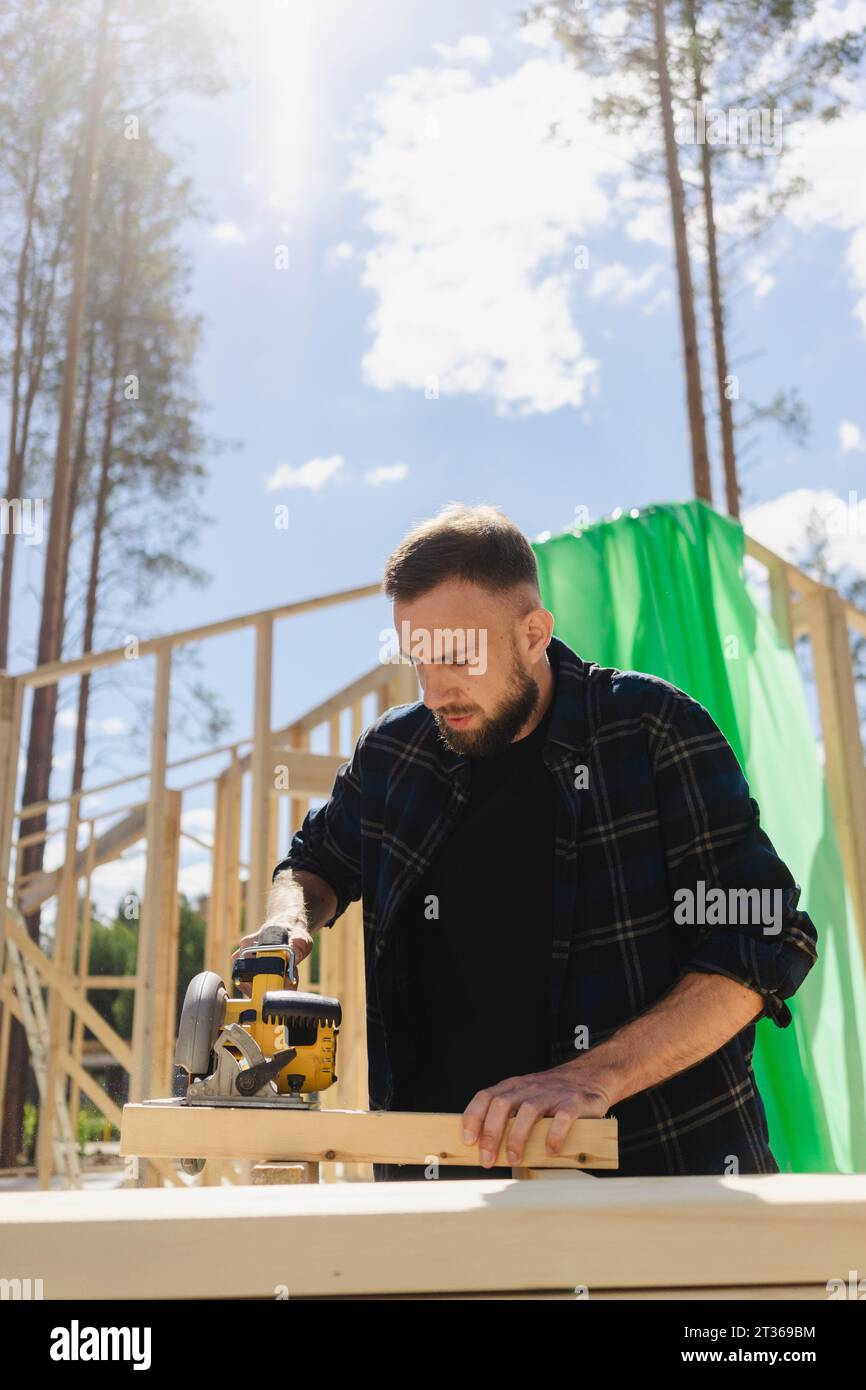 Engineer working with equipment on plank at construction site Stock Photo