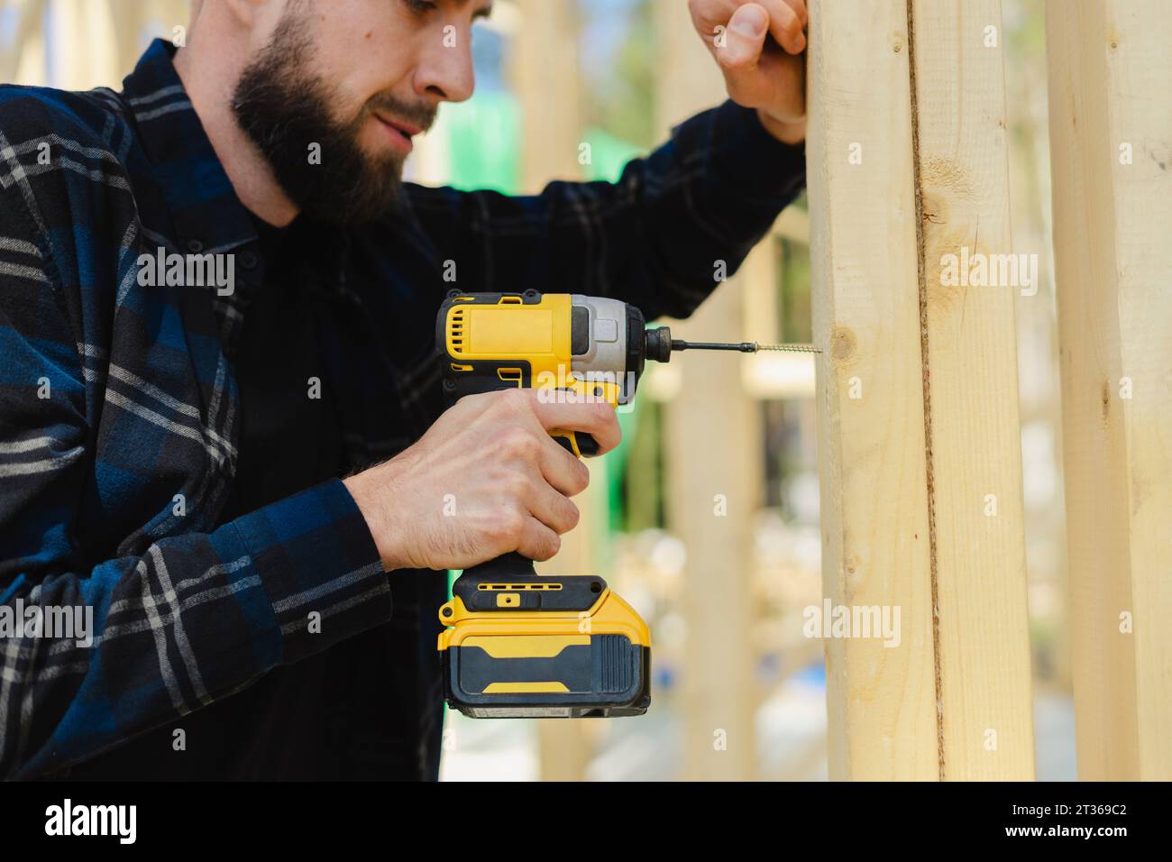 Bluecollar worker drilling wood at construction site Stock Photo Alamy