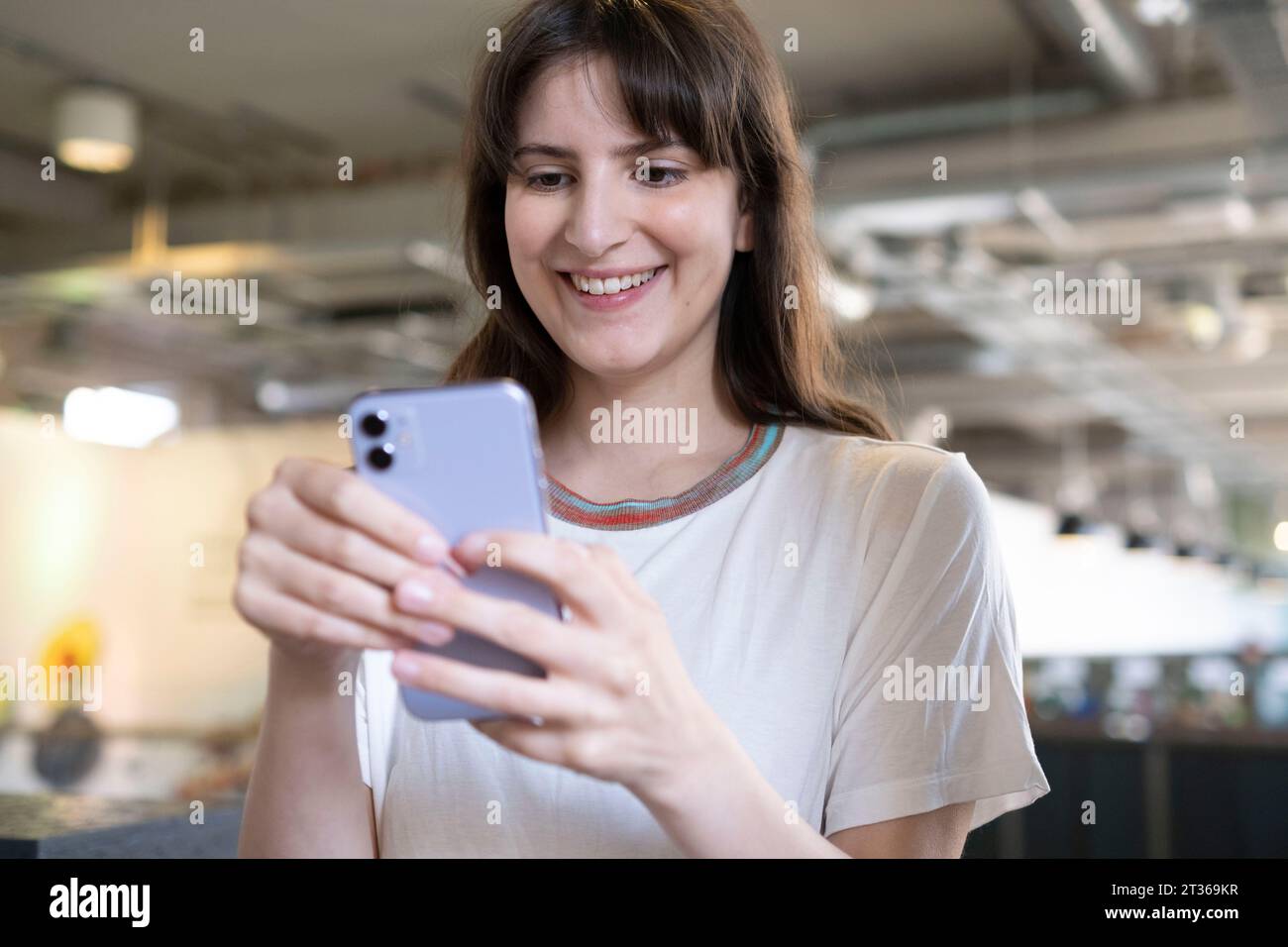 Smiling woman using smart phone Stock Photo