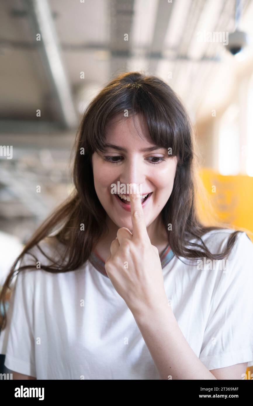 Happy woman touching nose with finger Stock Photo