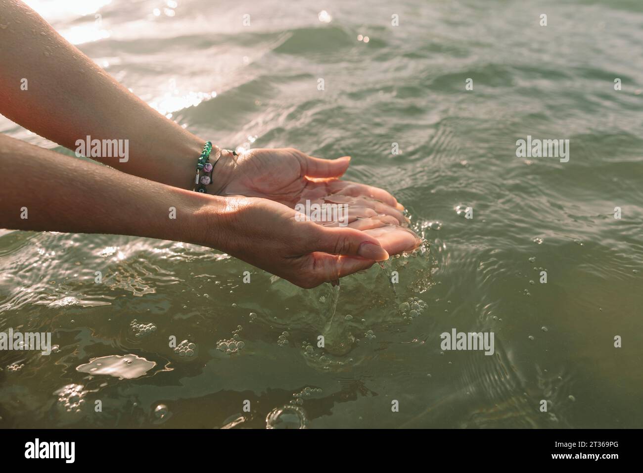 Woman holding water with cupped hands at beach Stock Photo