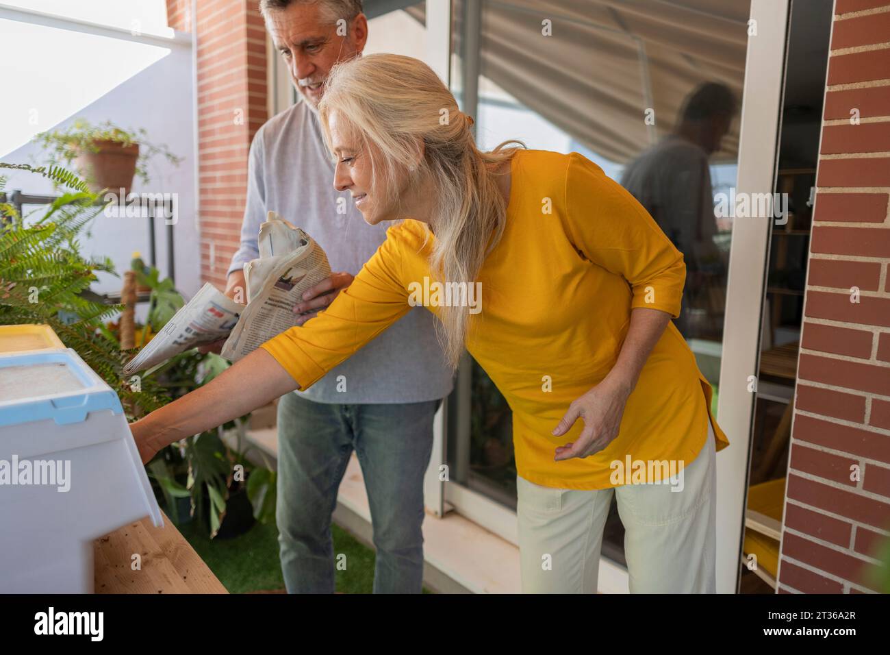 Man and woman doing chores in balcony Stock Photo