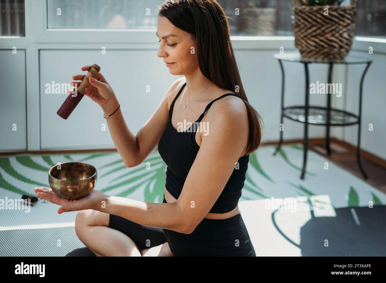 Smiling woman doing meditation with rin gong at home Stock Photo