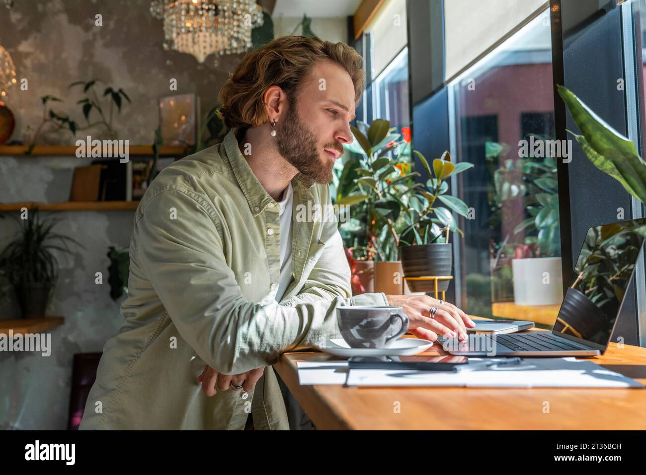 Young businessman working on laptop at cafe Stock Photo