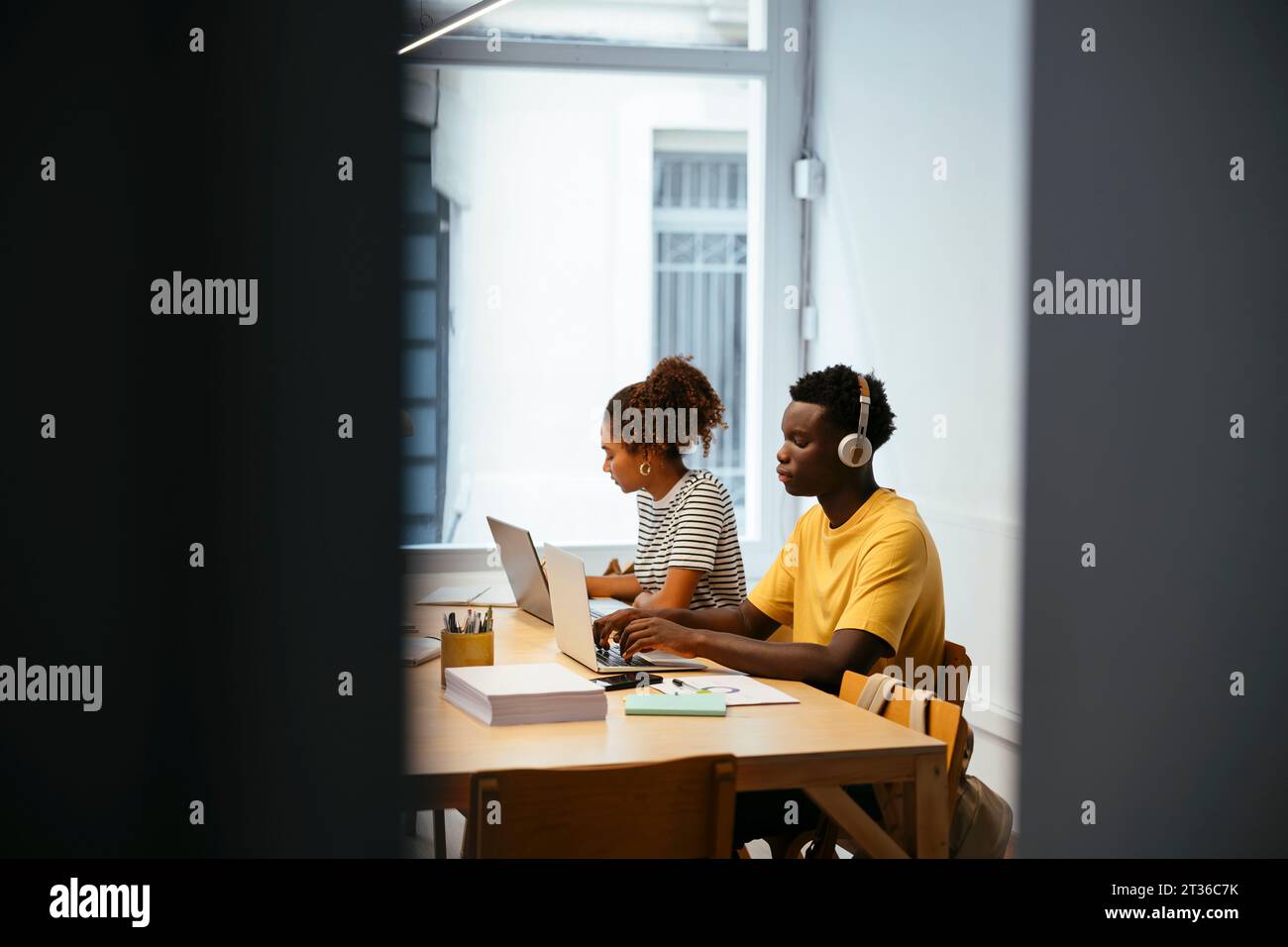 Young students studying and using laptop at desk Stock Photo