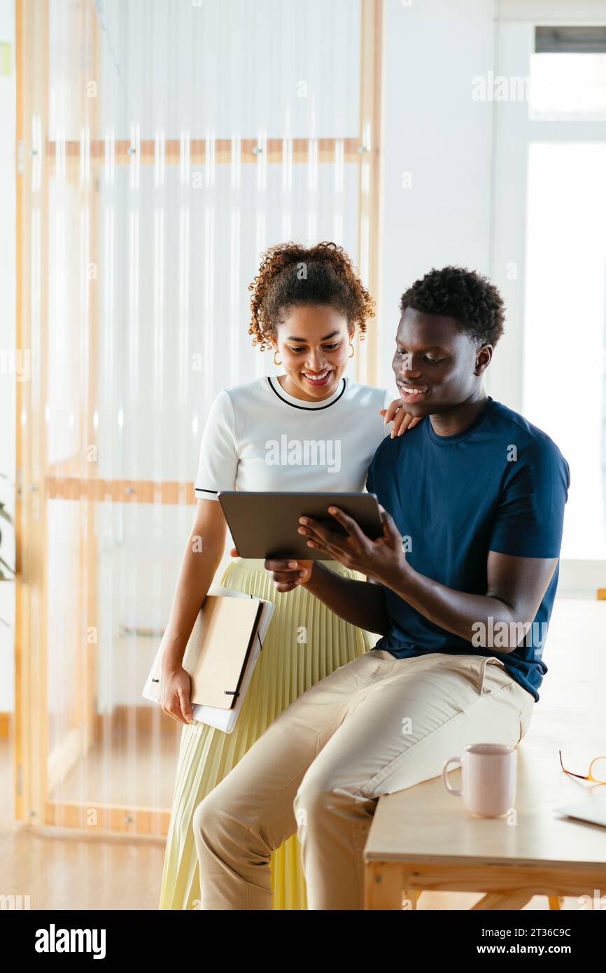 Smiling young students using tablet PC at university Stock Photo
